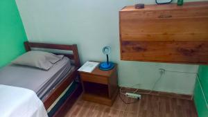 a small bedroom with a bed and a table with a lamp at Kemmiu single room in São Tomé
