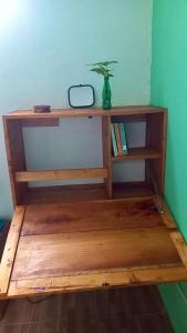 a wooden shelf with a plant on top of it at Kemmiu single room in São Tomé