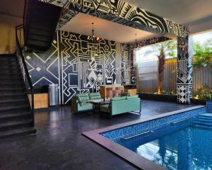 a living room with a swimming pool next to a house at Atmosfera Bengaluru, India in Bangalore