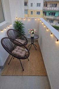 a balcony with two chairs and a table and lights at Apartament by DANIA&PETRU in Târgu Ocna