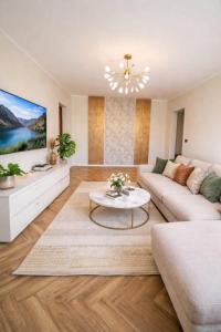 a living room with a couch and a table at Apartament by DANIA&PETRU in Târgu Ocna