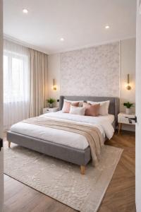 a large bedroom with a large bed with pink pillows at Apartament by DANIA&PETRU in Târgu Ocna