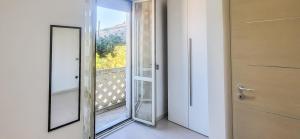 eine offene Tür zu einem Balkon mit einem Spiegel in der Unterkunft Corte Dolia in Dolianova