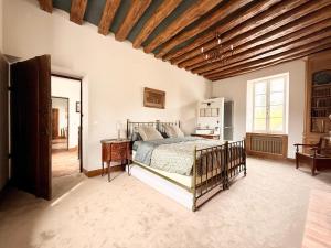 a bedroom with a bed and a wooden ceiling at Former riverside rectory in Nanteau-sur-Lunain