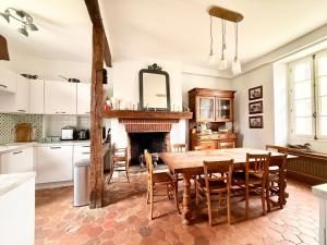a kitchen with a table and a fireplace at Former riverside rectory in Nanteau-sur-Lunain