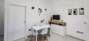 ein weißes Zimmer mit einem weißen Tisch und Stühlen in der Unterkunft Corte Dolia in Dolianova