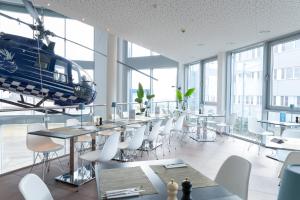 a helicopter in a room with tables and chairs at Aircraft Hotel & Events in Neuhausen ob Eck
