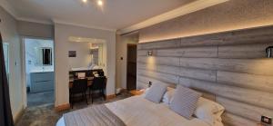 a bedroom with a wooden wall with a bed and a desk at The Royal Hotel in Liverpool