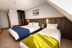 a hotel room with two beds and a yellow blanket at Brit Hotel Calais in Calais +21 photos