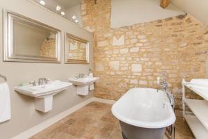 a bathroom with two sinks and a tub and two mirrors at Week Farm Manor in Wellow +18 photos