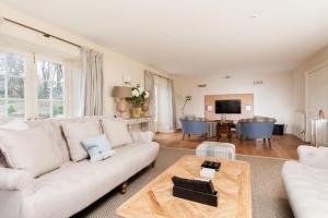 a living room with a white couch and a table at Week Farm Manor in Wellow
