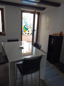 a kitchen with a white table and chairs and a window at Casa Willo in Bellinzona