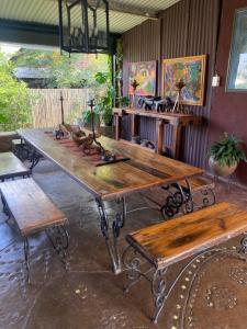 a large wooden table and benches in a room at Bohemian Garden Cottages in Kaapsehoop