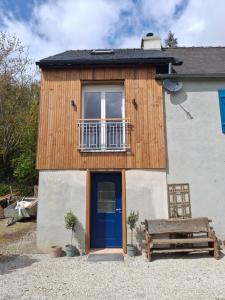 a small house with a blue door and a bench at Cottage en Saule in Port-Launay