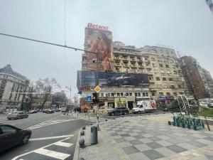 a city street with a building with a car billboard at Central Designer Condo in Bucharest