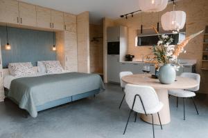 a bedroom with a bed and a table and chairs at Polderlodge de Ontmoeting in Goudriaan