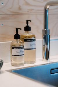 two bottles of soap sitting on a bathroom sink at Polderlodge de Ontmoeting in Goudriaan