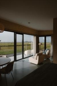 a bedroom with a bed and a table and chairs at Polderlodge de Ontmoeting in Goudriaan