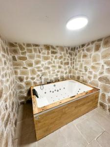 a bath tub in a room with a stone wall at Cocon détente & Jacuzzi(Balnéo) in Dieppe +13 photos