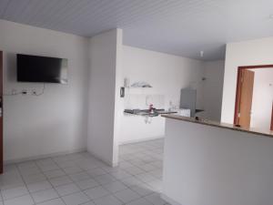 a white room with a counter and a tv on a wall at Apartamento in Parnamirim +6 photos
