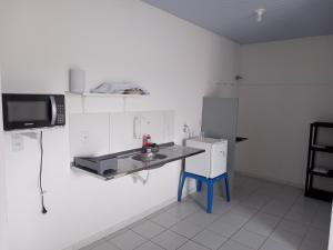 a small kitchen with a sink and a tv on the wall at Apartamento in Parnamirim