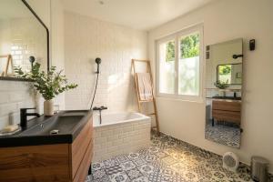 a bathroom with a tub and a sink and a mirror at Villa 10-14 guests - 180m2 - private forest - CDG 7min - Disney 20min in Claye-Souilly