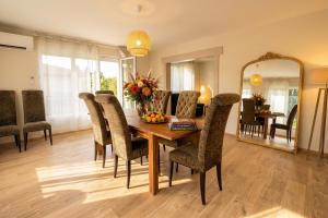 a dining room with a table and chairs and a mirror at Villa 10-14 guests - 180m2 - private forest - CDG 7min - Disney 20min in Claye-Souilly