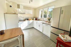 a kitchen with white cabinets and a refrigerator at Villa 10-14 guests - 180m2 - private forest - CDG 7min - Disney 20min in Claye-Souilly