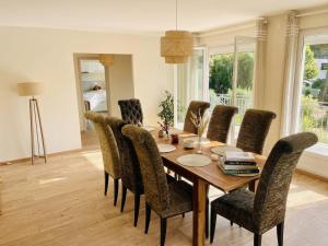 a dining room with a wooden table and chairs at Villa 10-14 guests - 180m2 - private forest - CDG 7min - Disney 20min in Claye-Souilly +23 photos