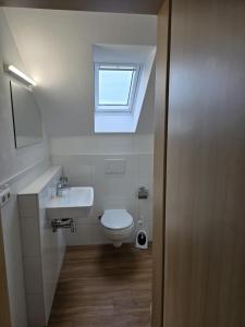 ein Badezimmer mit Toilette, Waschbecken und Fenster in der Unterkunft AlbFreizeit in Göppingen