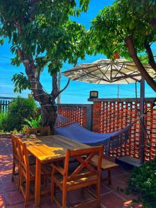 a hammock on a patio with a table and chairs at Ruhigen Homestay Phan Rang in Thôn Ðông Giang