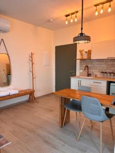 a kitchen with a wooden table and blue chairs at sunrise valley - זריחת העמק in Yavneʼel
