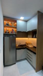 a kitchen with a stainless steel refrigerator and cabinets at Apartamento a 50m da praia em Camocim CE in Camocim