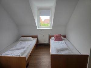 zwei Betten in einem kleinen Zimmer mit Fenster in der Unterkunft AlbFreizeit in Göppingen