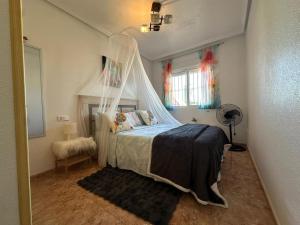 a bedroom with a bed with a mosquito net at BEACH AND CHILL APARTMENT con encanto in Los Alcázares
