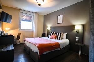 a hotel room with a bed and a window at Logis Hôtel Le Mas De Jossyl in La Roque-dʼAnthéron