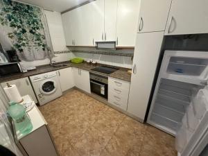 a kitchen with white cabinets and a washer and dryer at BEACH AND CHILL APARTMENT con encanto in Los Alcázares