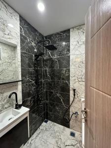 a bathroom with a shower with black and white tiles at Tree Rose Suite in Uzungöl +40 photos