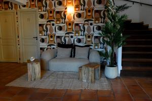 a living room with a couch and a potted plant at Logis Hôtel Le Mas De Jossyl in La Roque-dʼAnthéron