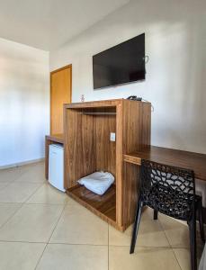 a room with a desk with a tv and a chair at Carlton Plaza Torre in Araxá