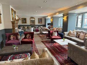 a living room with couches and chairs and a fireplace at Dunalastair Hotel Suites in Kinloch Rannoch