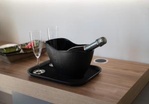 a bottle of wine in a bucket on a table with glasses at Alfiri 890 in Santa Maria Pietrafitta