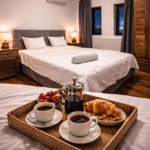 a breakfast tray with coffee and food on a bed at ng royal in Rakitovo