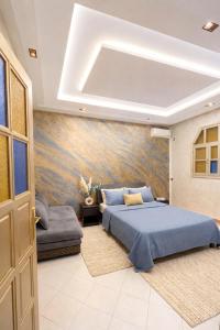 a bedroom with a blue bed and a couch at Luxury apartment and duplex in Ouarzazate