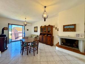 a living room with a table and a fireplace at Mirto House in Cardedu