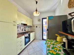 a kitchen with white cabinets and a stove top oven at Mirto House in Cardedu +17 photos