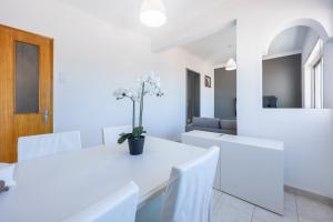 a white dining room with white tables and white chairs at Incredible view - T2 Ribeirinha in Portimão