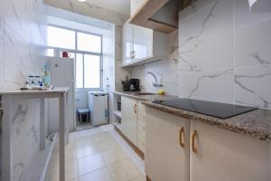 a kitchen with white walls and marble counter tops at Incredible view - T2 Ribeirinha in Portimão