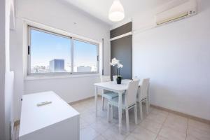 a dining room with a table and chairs and a window at Incredible view - T2 Ribeirinha in Portimão