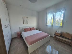 a bedroom with a large bed and a window at דירת נופש נווה ים in Kefar HaNo‘ar Niẕẕanim